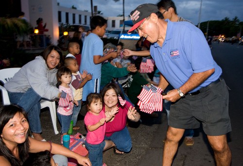 Hilo Christmas Parade Russell Hayashi of the Exchange Club passes out flags to the crowd during the Lehua Jaycees Island Style Christmas parade in Hilo.