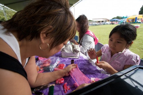 20090110_crafts Letty Galoway, left, helps Niann Penaroza, 10 years-old, work on a crafts project creating flowers at the Queen Liliuokalani Children's Center booth during the Family Fun Day at Kurtistown Park.