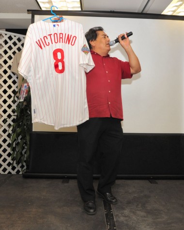 haw247_8421 Auctioneer J.E. Orozco holding an autographed Shane Victorino World Series jersey which eventually sold for $700 to a lucky bidder.