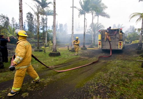 20090325_ainaloa-fire-hoses Firefighters lead out hoses to a tanker unit while putting out a structure fire on Ainaloa Drive in Puna.