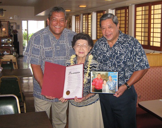 20090629_kenoi-teshima-lau Mayor Billy Kenoi and Deputy Managing Director Wally Lau present Shizuko Teshima with a commendation recognizing her 102nd birthday in the landmark family restaurant, Teshima's, which is located in Honalo.