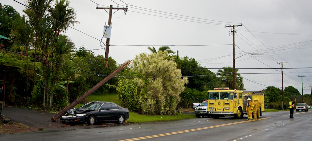 A car in the Puna bound lane of Kilauea Avenue severs a utility pole near E Palai Street.