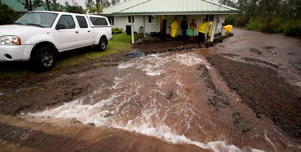 Firefighters protect a home from flood waters in Ainaloa Subdivision Saturday (Nov 14).