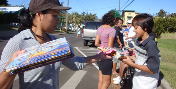 Volunteers link up along Akoni Pule Highway to transfer thousands of books in just two hours