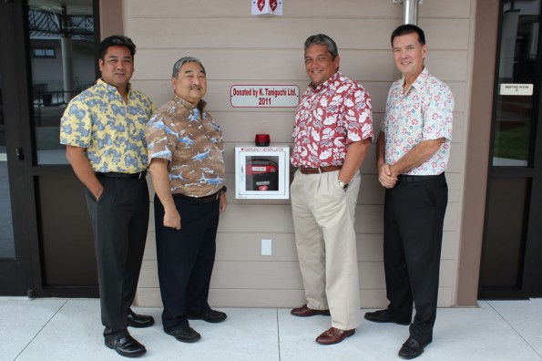 kta-aed-donation-to-whcc Toby Taniguchi and Barry Taniguchi of KTA Super Stores, Mayor Billy Kenoi, and Bobby Command of the County stand with one of the new AEDs donated by the Taniguchis.