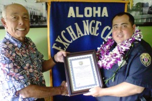 OfficerOfTheMonth-Feb-Watkins Hilo Exchange Club Board Member Joey Estrella presents an "Officer of the Month" for February plaque to Officer Luke Watkins.