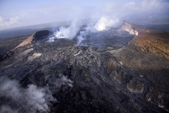 Eruptive activity in Puʻu ʻŌʻō has picked up over the past week. Lava flows erupting sporadically from several places continue to fill the crater and occasionally spill out onto the east flank of Puʻu ʻŌʻō. This view, looking southwest, shows new lava from active and recent flows on Puʻu ʻŌʻō's eastern flank. Many of the flows come directly from the small perched lava lake on the northeast side of the crater floor, visible at the center of the photo. Photo courtesy of USGS/HVO