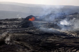 This photo, looking south, shows lava spilling from the small, perched lava lake on the northeast side of Puʻu ʻŌʻō's crater floor. The rim on the east side of the crater, in the background, has been nearly completely buried and is no longer discernable. Photo courtesy of USGS/HVO