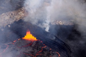 Spattering is common in the area where lava sinks back into the system, and this photo shows these processes are occurring in a small grotto. In the right portion of the photo, the ledge occupying much of the south part of the Overlook crater is visible. Parallel lines along the front face of this ledge might appear at first glance to be layering within the ledge, but are actually thin deposits of lava that mark recent levels of the lava lake, much like bathtub rings. Photo courtesy of USGS/HVO