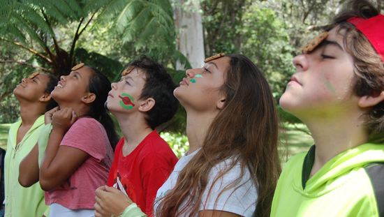 Parker middle schoolers trying to get a cookie from forehead to mouth in a team-building game at their annual campout. (Photo courtesy of Parker School)
