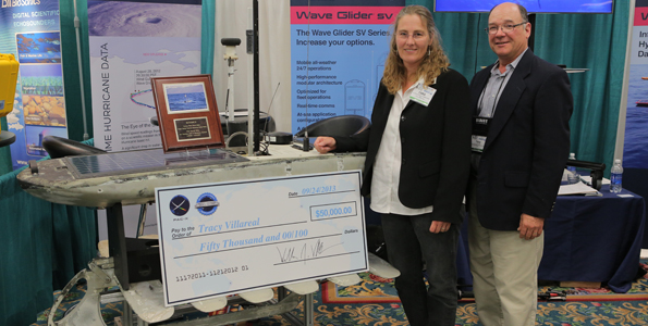 Dr. Villareal and Dr. Cara Wilson pose in front of Wave Glider Benjamin. (Photo courtesy of Liquid Robotics)