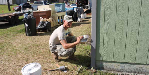 Sgt. Dallas Keck, Section Chief from 2nd Battalion, 11th Field Artillery Regiment, 2nd Stryker Brigade Combat Team, 25th Infantry Division touches up garage trim paint. (Photo courtesy of 2nd Lt. Sheme Hicks | U.S. Army)