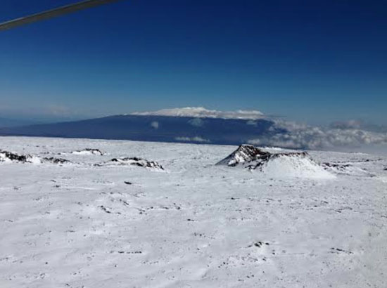 Snow-covered Mauna Loa with the cindercone Pohaku o Hanalei in foreground, near where Sverdlov was spotted. Snow-covered Mauna Kea is seen in the distance. (Photo courtesy of David Okita | Search-and-rescue pilot)