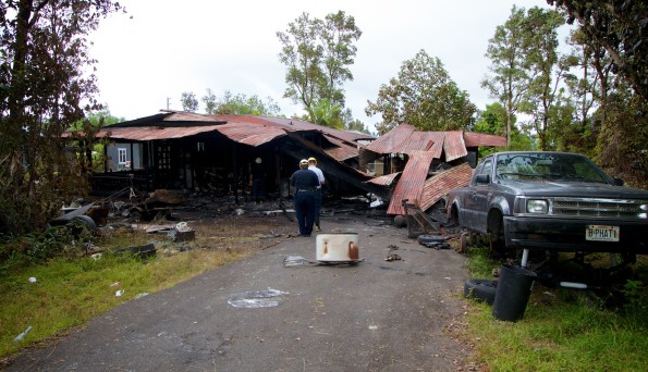 Police and Fire Department personnel investigate the cause of the fire which burned a Kaumana home Friday (June 27). Photography by Baron Sekiya | Hawaii 24/7