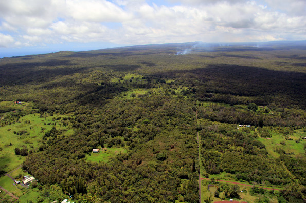 This wide view taken Monday (Sept 1), looking west, shows the position of the June 27th flow front relative to the nearby Kaohe Homesteads subdivision. The front of the flow is moving through thick forest, and its position can be seen by the plumes of smoke above the center of the photograph. Near these active surface flows, there was also steaming from a ground crack, resulting from lava deep in the crack. The farthest point of this steaming was 1.7 km (1.1 miles) West of the boundary of the Kaohe Homesteads subdivision. Photo courtesy of USGS/HVO