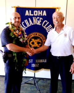 Aloha Exchange board member Joey Estrella presents an 'Officer of the Month' award to Officer Roberto Segobia
