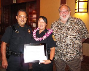 Lieutenant Juergen Canda and Randy Crowe, president of the Hawaii Island Safety and Security Professionals Association, present a "Kohala Officer of the Quarter" award to Community Policing Officer Kristi Crivello.