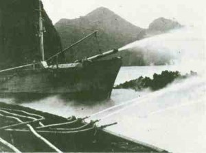 Sandey and Lóðsinn pumping sea water onto the forward margin of the lava at the breakwater (Photograph courtesy of Sigurgeir Jónasson, March 1973).