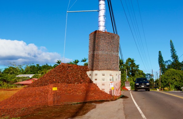 A utility pole hardened against the heat of the lava flow alongside Pahoa Village Road on Sunday, December 7, 2014. Protection material has been pushed off the roadway so it could open to traffic. Photography by Baron Sekiya | Hawaii 24/7