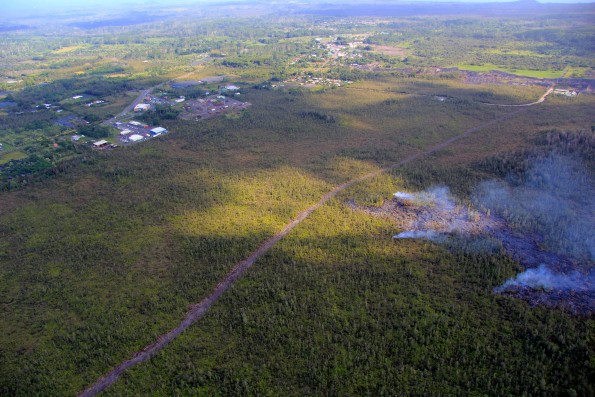 Kīlauea’s East Rift Zone lava flow remains active upslope from the Pahoa Marketplace area, visible at upper left, though activity has waned over the past week. The flow was very close to a firebreak road cut several months ago. The Pahoa Transfer Station is at upper right. The view is to the Southeast. Photo taken Monday, December 22, 2014 courtesy of USGS/HVO