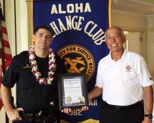 Aloha Exchange board member Joey Estrella presents an 'Officer of the Month' award to Officer Jacob Obermiller.