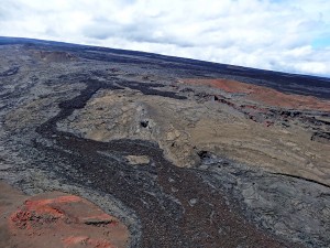 Five different flows—two erupted prehistorically and three others erupted in 1855, 1880, and 1899—are visible in the lower two-thirds of this image of Mauna Loa’s Northeast Rift Zone. To construct a geologic map of this area, USGS Hawaiian Volcano Observatory geologists initially used lava flow type, rock colors, and relative stratigraphic positions to distinguish between individual lava flows, and then relied on laboratory analyses and age-dates of the flows to refine their field mapping. USGS Photo