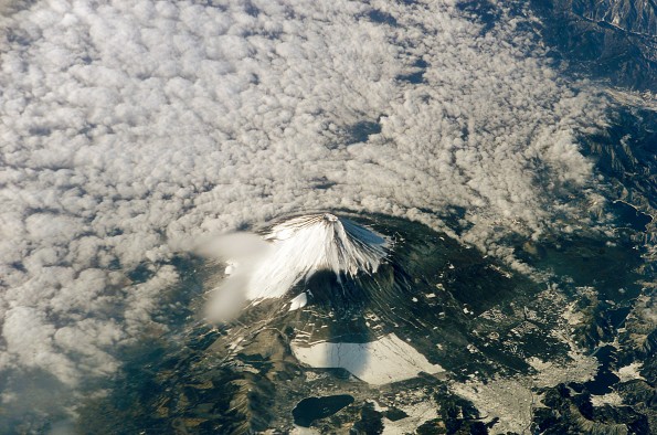 Mount Fuji on the island of Honshu, Japan. The snow-capped inactive volcano, surrounded at lower levels by clouds in this image, lies several miles south of Tokyo. January 26, 2003 Photo via the ill fated Space Shuttle Columbia mission by NASA.