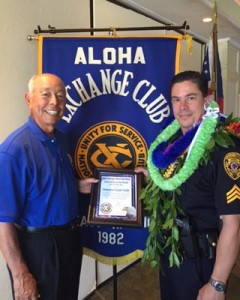 Aloha Exchange Club member Joey Estrella presents an 'Officer of the Month' award to Detective Grant Todd.