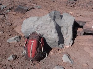 This light gray block of rock (backpack for scale) is part of the approximately 830-year-old explosion deposit on the northwest rim of Moku‘āweoweo, the summit caldera of Mauna Loa. USGS photo by F.A. Trusdell.