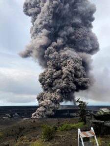 Ash column rises from the Overlook crater at the summit of Kīlauea Volcano. HVO's interpretation is that the explosion was triggered by a rockfall from the steep walls of Overlook crater. The photograph was taken at 8:29 a.m. HST from the Jaggar Museum overlook. The explosion was short-lived. Geologists examining the ash deposits on the rim of Halema‘uma‘u crater found fresh lava fragments hurled from the lava lake. This explosion was not caused by the interaction of the lava lake with the water table. When the ash cleared from the crater about an hour after the explosion, geologists were able to observe the lava lake surface, which is still above the water table. Photo taken Wednesday, May 9, 2018 courtesy of U.S. Geological Survey