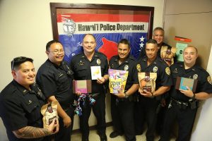 South Hilo Patrol Officers display gifts and a card that were sent to an injured Honolulu Police Officer and his K-9 Hunter