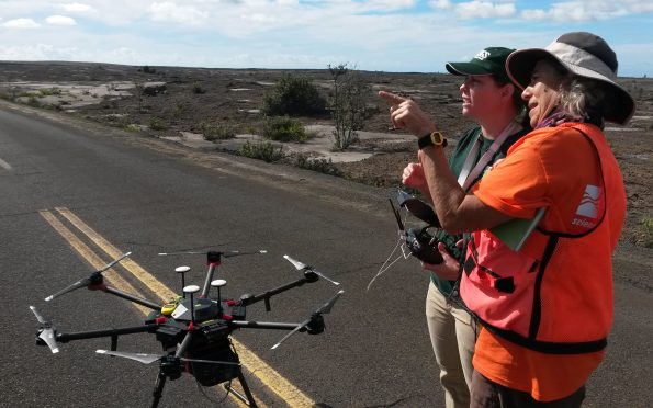 A USGS pilot and Hawaiian Volcano Observatory gas geochemist prepare to conduct a test flight of an unmanned aerial system (UAS) on Kīlauea Volcano in November 2018. This UAS was outfitted with a prototype miniaturized multi-gas sensor for the detection of volcanic gases emitted by Kīlauea, including sulfur dioxide and carbon dioxide. USGS photo by Patricia Nadeau.